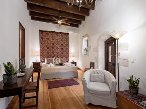 a bedroom with a bed and a chair and a table at Venetian Palace Chania in Chania