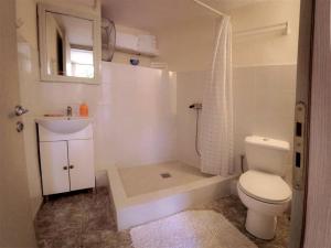 een badkamer met een toilet, een wastafel en een douche bij Jacob's Sunrise cottage in Kissamos
