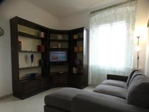 a living room with a couch and a tv and a window at CA' ARGENTINA Appartamento Vista MARE in La Spezia