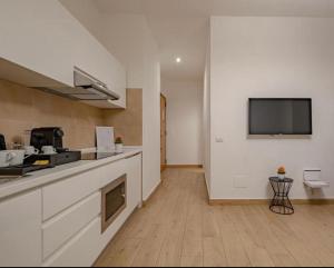 une cuisine avec un comptoir et une télévision sur un mur dans l'établissement ByMe Torino 85, à Turin 6 autres photos