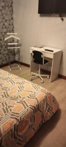 1 dormitorio con escritorio, 1 cama y 1 silla en Corneguerre Grand Brassac, en La Peyzie