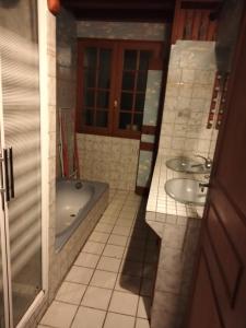 a bathroom with two sinks and a bath tub at Corneguerre Grand Brassac in La Peyzie