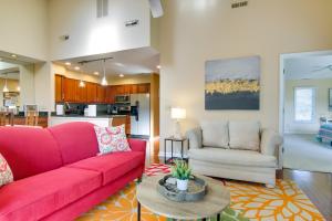 a living room with a red couch and a table at Condo with 2 Balconies and 3 Pools Less Than 2 Mi to Beach! in Rehoboth Beach