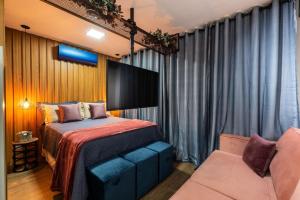 um quarto com uma cama e um sofá em Kaza Noah Sky Pauliceia em São Paulo