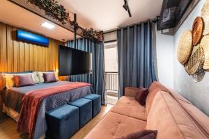 um quarto com uma cama e um sofá em Kaza Noah Sky Pauliceia em São Paulo