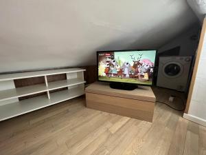 ein Wohnzimmer mit einem Flachbild-TV und einem Lautsprecher in der Unterkunft Apartment A.C.& G.O. Milan in Mailand