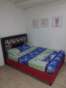 a bed with a blue comforter in a bedroom at Apartaestudio buenos aires in Barrancabermeja +1 photo