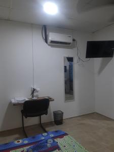 a room with a chair and a fan and a mirror at Apartaestudio buenos aires in Barrancabermeja