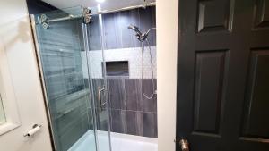 een douche met een glazen deur in de badkamer bij Home in Syracuse/Ranch Style in Syracuse