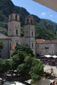 dos torres de un antiguo edificio con árboles delante en Montenegro Backpackers Home Kotor, en Kotor