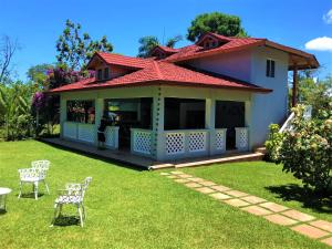 una casa con mesa y sillas en un patio en Villa Los Caciques By Hospedify - Hermosa Villa con Piscina, Billar, Zona de BBQ y Domino, en Jarabacoa