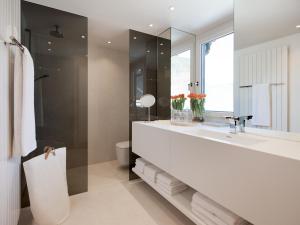 ein Badezimmer mit einer großen weißen Badewanne und einem Waschbecken in der Unterkunft Boutique Apartments Bezau in Bezau