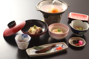 una tavola ricoperta di ciotole e piatti di alimenti di Hatsunoyu a Yamanouchi Altre 25 foto