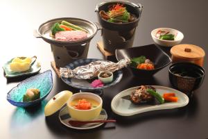 una tavola ricoperta di ciotole e piatti di alimenti di Hatsunoyu a Yamanouchi