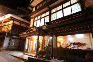 an asian building with lit windows at night at Hatsunoyu in Yamanouchi