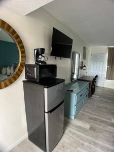 a room with a kitchen with a refrigerator and a microwave at The anchor hotel in Myrtle Beach