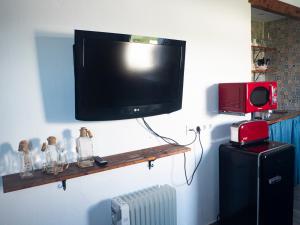 TV de pantalla plana colgada en la pared en Estudio Capricho en Vejer de la Frontera
