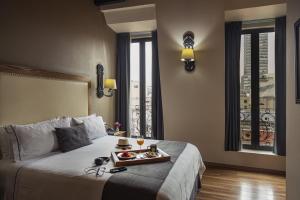 una stanza d'albergo con un letto con un vassoio di cibo sopra di Historico Central Hotel a Città del Messico
