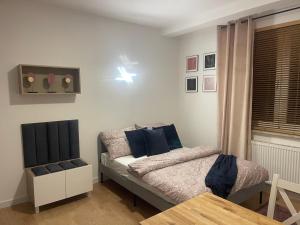 - un salon avec un lit et une table dans l'établissement MW 5A Apartament, à Rzeszów