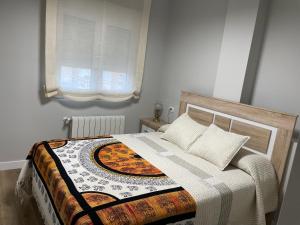 a bedroom with a bed with a quilt on it at Apartamento Centro de Jaén in Jaén