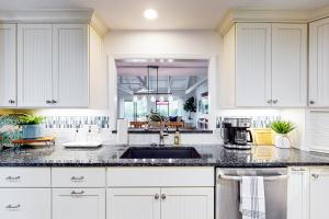 a kitchen with white cabinets and a sink at Queens Grant 684 in Hilton Head Island