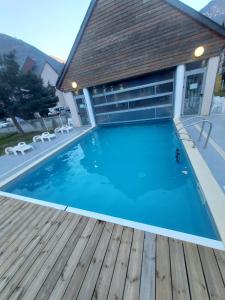 una gran piscina con terraza de madera en Appartement Duplex dans Résidence VAL DE ROLAND, en Luz-Saint-Sauveur