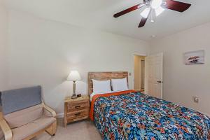 een slaapkamer met een bed en een stoel en een plafondventilator bij World Tour Retreat in Myrtle Beach