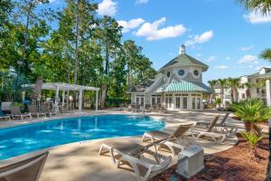 een zwembad met stoelen en een huis bij World Tour Retreat in Myrtle Beach