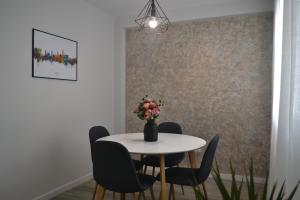 a dining room table with chairs and a vase with flowers at Victoria Flat F&M Moderno, acogedor y céntrico in Málaga