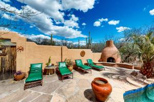 a patio with green chairs and a wall at Saguaro Sanctuary in Tucson
