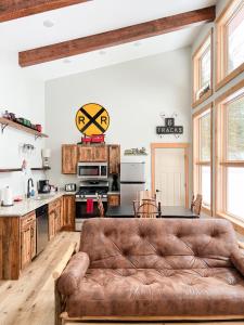 a living room with a brown couch in a kitchen at Cranberry Inn in Mercer