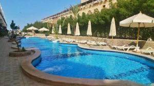 a pool at a hotel with chairs and umbrellas at El captain Resort in Hurghada