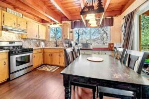 a large kitchen with a table and a stove at Cozy Moon Cabin in Big Bear Lake