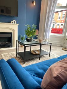 a blue living room with a blue couch and a table at Manchester House in Blackpool