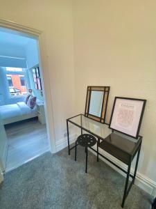 a room with a glass table and a mirror at Kingdom Lodgings in Blackpool