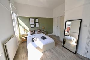 a bedroom with a large white bed and a mirror at Manchester House in Blackpool