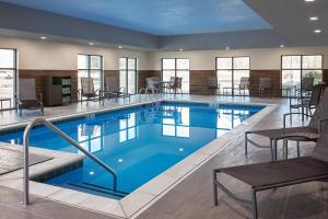 a swimming pool in a hotel with tables and chairs at Fairfield Inn & Suites by Marriott Virginia Beach/Norfolk Airport in Virginia Beach