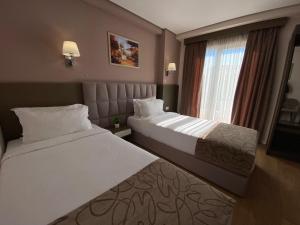 a hotel room with two beds and a window at Doanesia Premium Hotel & Spa in Tirana