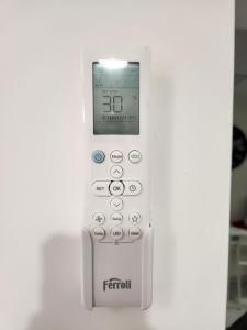 a remote control with a clock on the wall at Suite SAN GENNARO in Naples