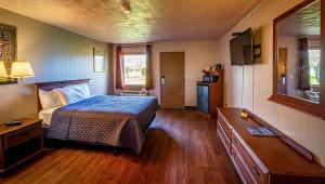 Magnuson Grand Harrisburg في نيو كمبرلاند: غرفة نوم فيها سرير وتلفزيون