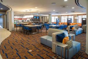 a restaurant with blue couches and tables and chairs at Courtyard by Marriott Pensacola Downtown in Pensacola