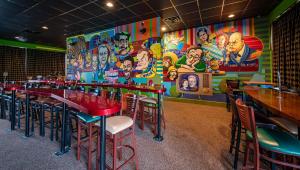 um restaurante com mesas e cadeiras e um mural em Magnuson Grand Harrisburg em New Cumberland