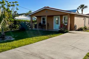 una pequeña casa con césped delante en Casa Capel, en Port Orange