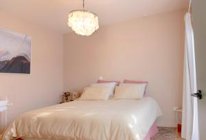 a bedroom with a white bed and a chandelier at The Castle in Greytown
