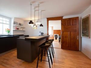 a kitchen with a island with bar stools at Boutique Apartments Bezau in Bezau