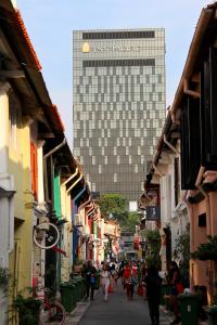 una calle de la ciudad con un edificio alto en el fondo en Pan Pacific Serviced Suites Beach Road, Singapore en Singapur