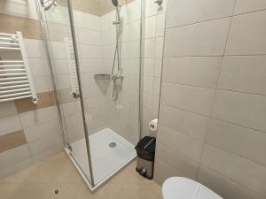 uma casa de banho com uma cabina de duche e um WC. em Aparthotel Mamaia em Mamaia