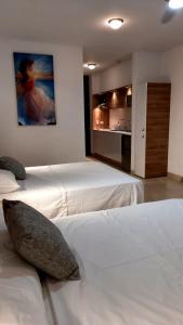 Makana Tonsupa - Suites Familiares 311 y 421 - Deluxe Suites في تونسوبا: غرفة نوم بسريرين ولوحة على الحائط