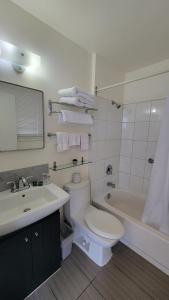 ein Badezimmer mit einem WC, einem Waschbecken und einer Badewanne in der Unterkunft Lord Nelson Motel in Kingston