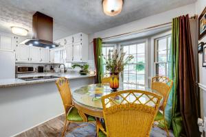 a kitchen with a glass table and chairs in a kitchen at Lush Covington Home with Patio about 32 Mi to Atlanta! in Covington